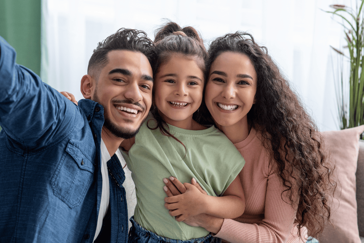 Happy family of three smiling together at Oxford family dentist office.